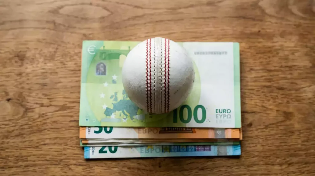 Taschenrechner neben einem Cricketball als Symbol für Wettsteuer bei Cricket Wetten